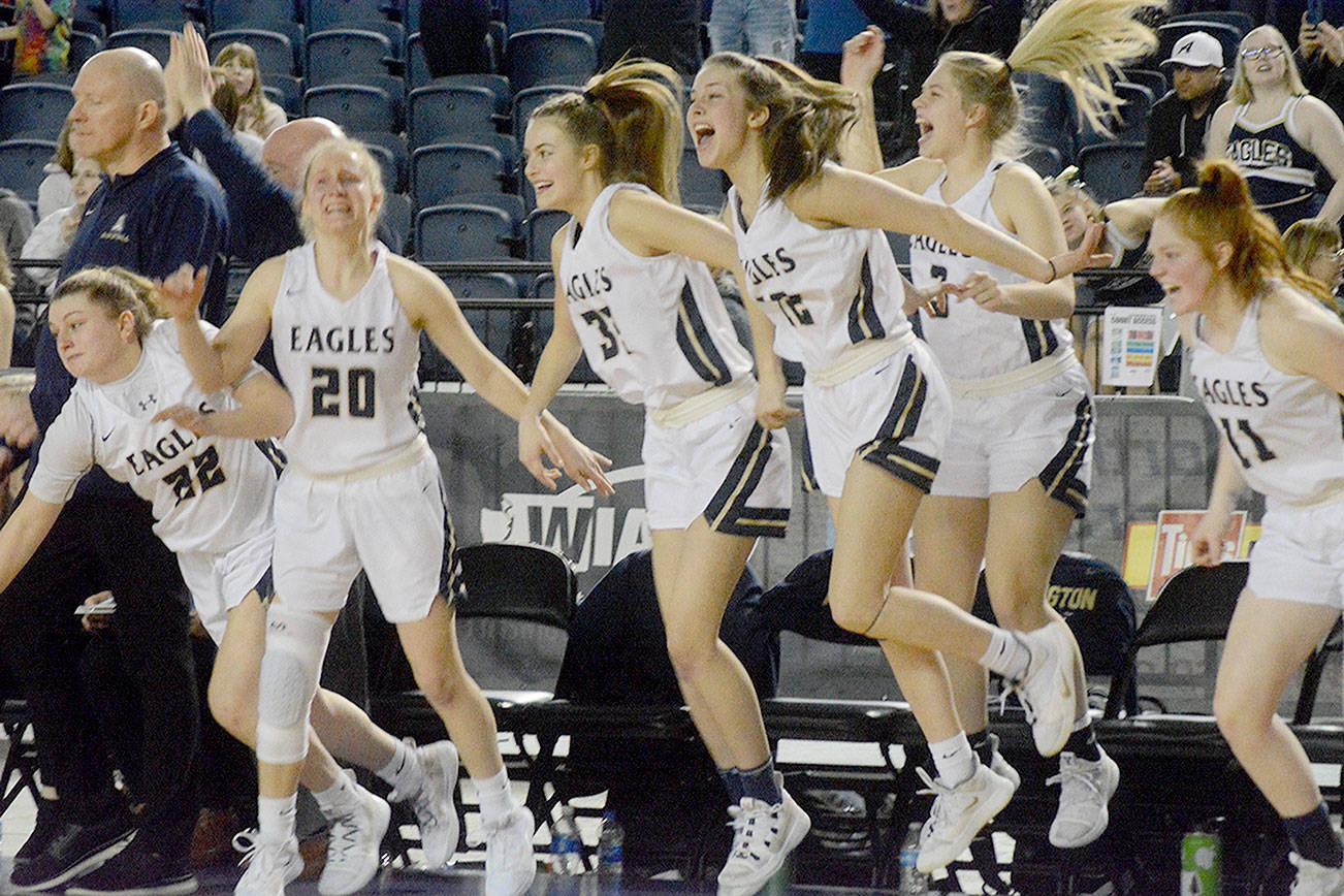 Arlington girls basketball team members celebrate as the horn sounds to end the upset against Eastside Catholic Saturday. (Steve Powell/Staff Photos)