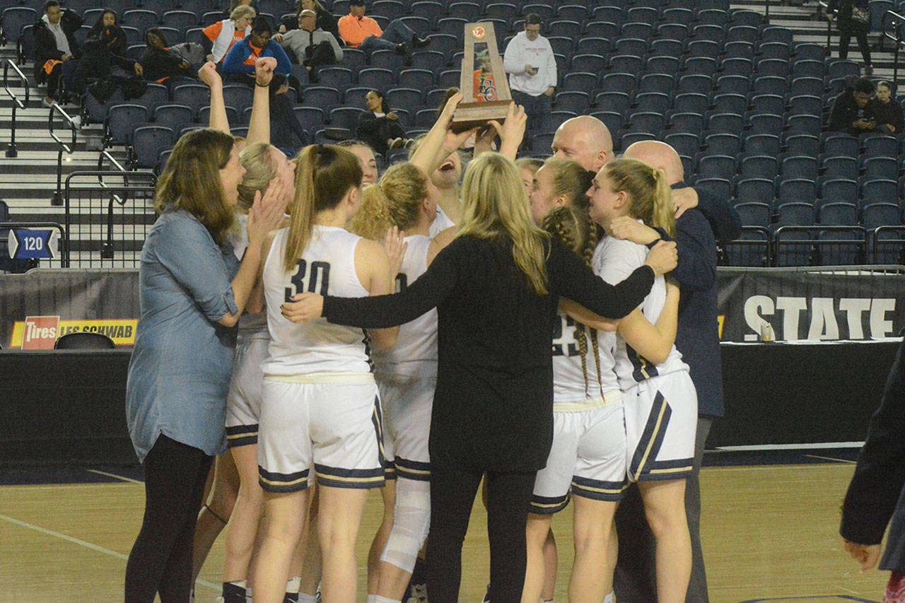 The Arlington girls basketball team hoists the team trophy for placing third at state.