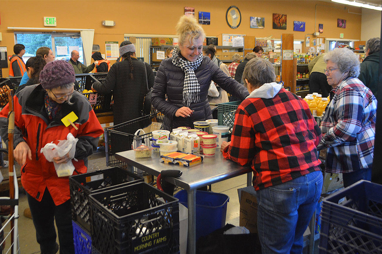 Food bank volunteers still can connect with customers. (Steve Powell/Staff Photos)