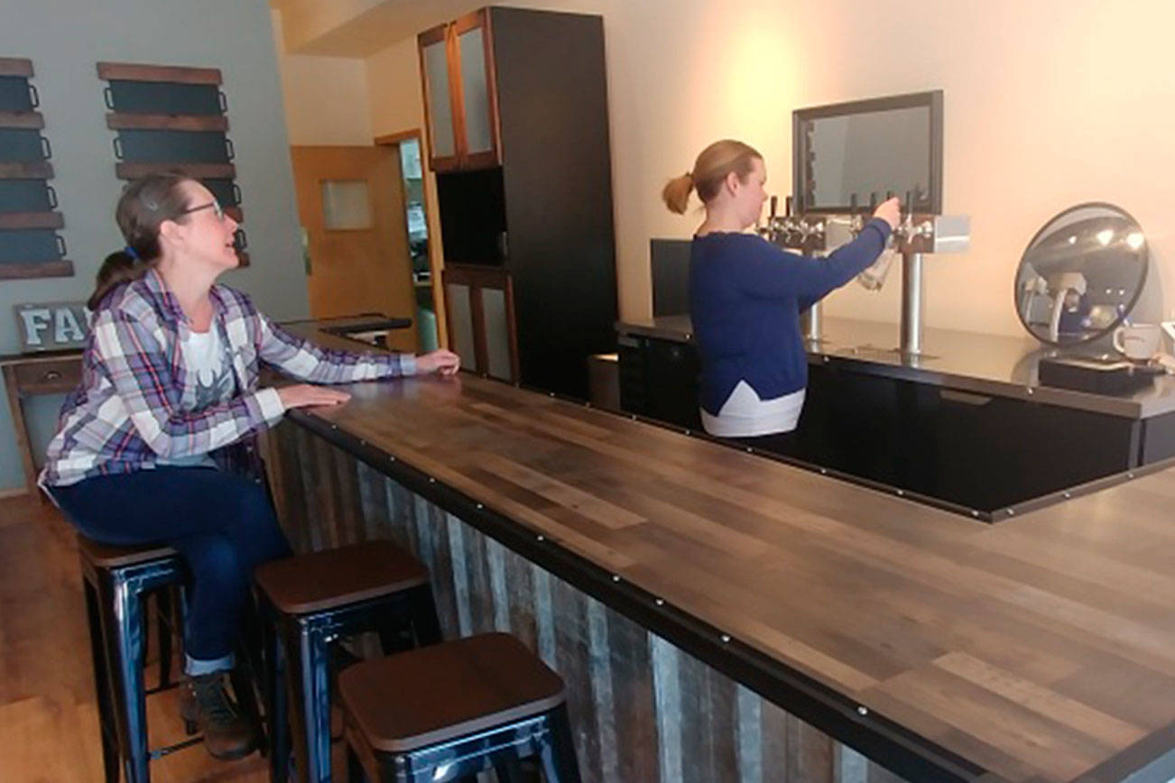 Arin Losier serves a beer at the new Woody’s bar in Marysville. (Steve Powell/Staff Photo)