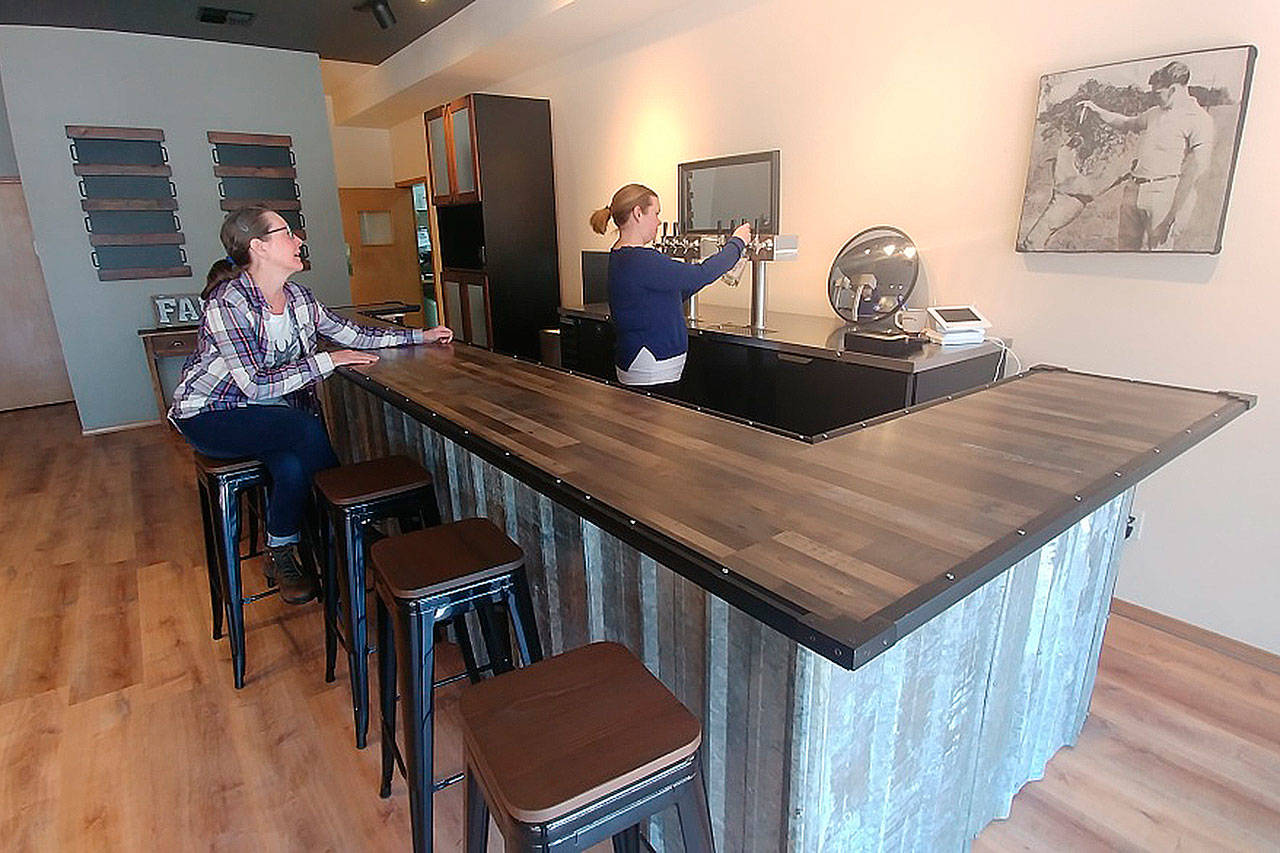 Arin Losier serves a beer at the new Woody’s bar in Marysville. (Steve Powell/Staff Photo)