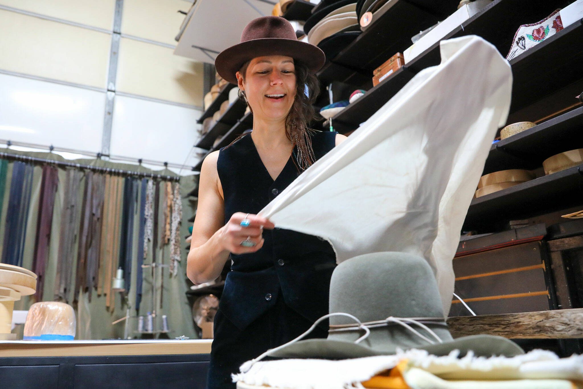 Jac Cash forms and shapes a hat at the FauxyFurr manufacturing shop in Arlington. (Kevin Clark / The Herald )