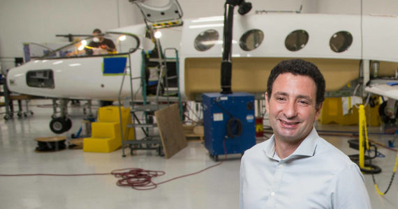 Eviation Co-founder and CEO Omer Bar-Yohay stands by the first all electric plane, the Alice, at Eviation's plant on Wednesday, Sept. 8, 2021 in Arlington, Washington.  (Andy Bronson / The Herald)