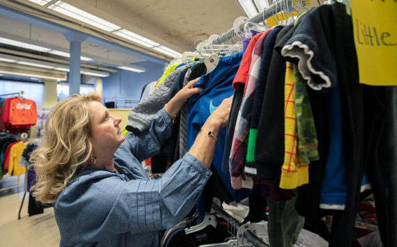 Director and Cofounder Kimberly Meno hangs up some new clothing at Arlington Kids’ Kloset on Thursday, Nov. 17, 2022, in Arlington, Washington. (Ryan Berry / The Herald)