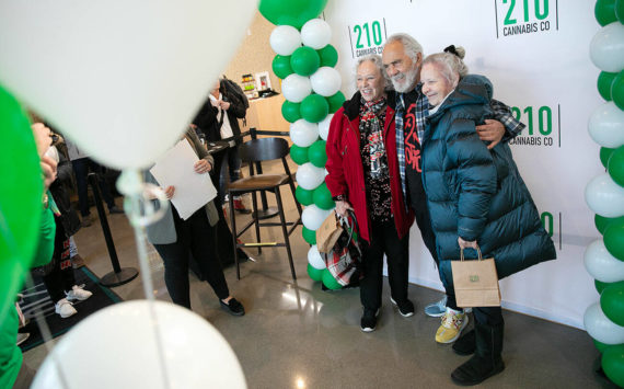 Carla Fisher and Lana Lasley take a photo together with Tommy Chong during 210 Cannabis Co’s grand opening Saturday, Dec. 10, 2022, in Arlington, Washington. Fisher and Lasley waited in line solely to get a photo with Chong. (Ryan Berry / The Herald)