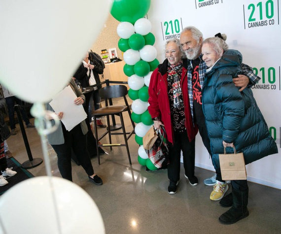 Carla Fisher and Lana Lasley take a photo together with Tommy Chong during 210 Cannabis Co’s grand opening Saturday, Dec. 10, 2022, in Arlington, Washington. Fisher and Lasley waited in line solely to get a photo with Chong. (Ryan Berry / The Herald)