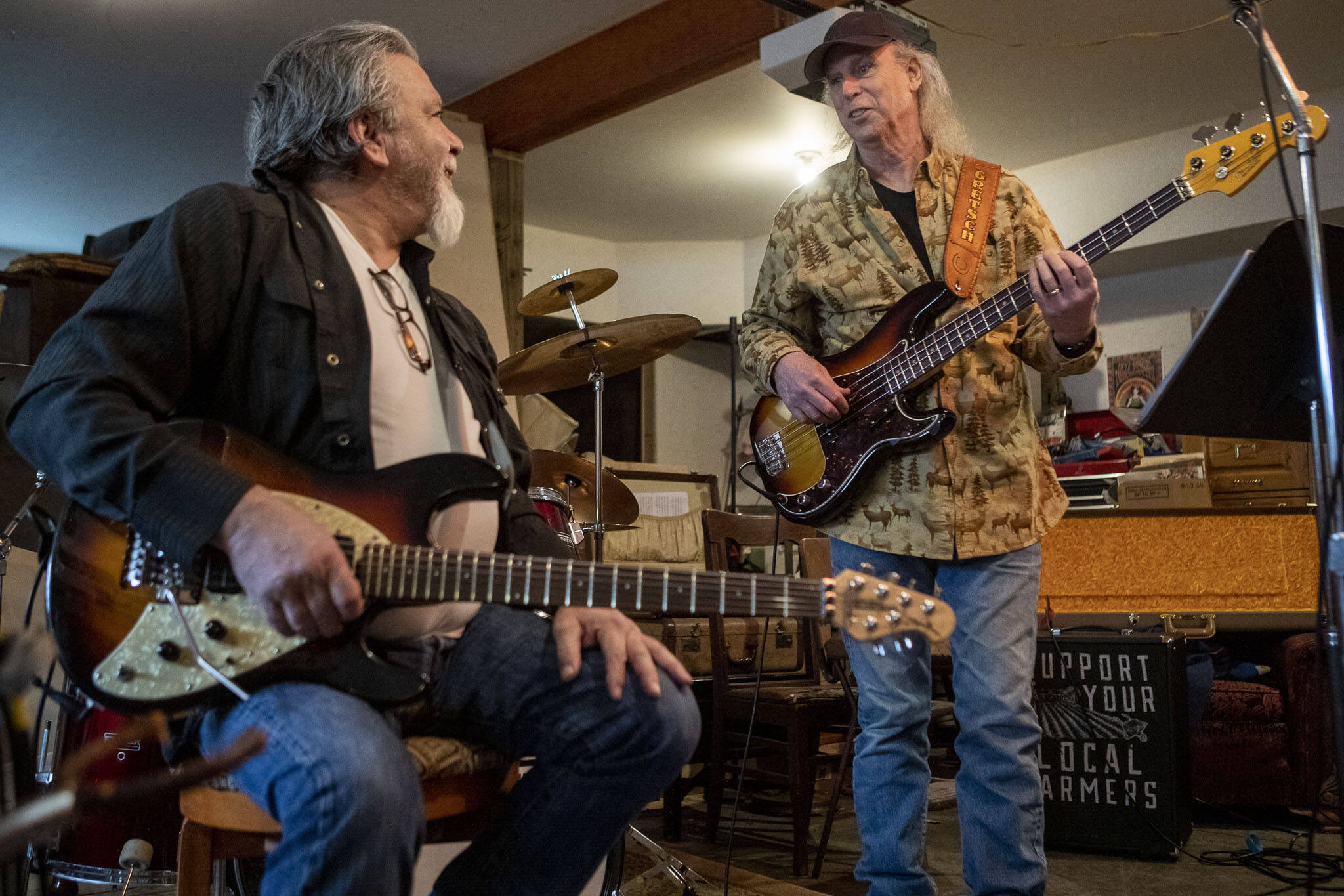 Lonnie Mueller, left, and Jim Kehoe chat during a Dan Canyon Band rehearsal in the group’s practice barn in Arlington, Washington, on Saturday, March 11, 2023. (Annie Barker / The Herald)